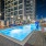 Apartments Near Piedmont Park - Mira At Midtown Union - Oversized Pool With Submerged And Poolside Lounge Chairs, Outdoor Lights, And Pergola.